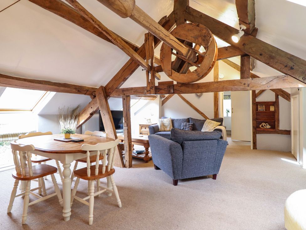 A living room with a table and chairs at Millers Loft, Llanrwst