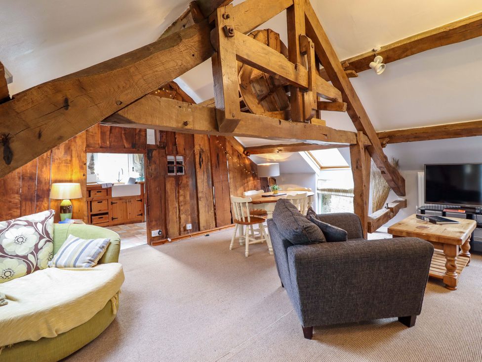 A living room with wooden beams and furniture at Millers Loft in Llanrwst