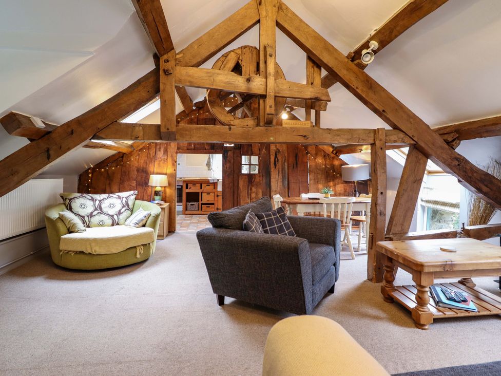 A living room with a sofa and table at Millers Loft in Llanrwst