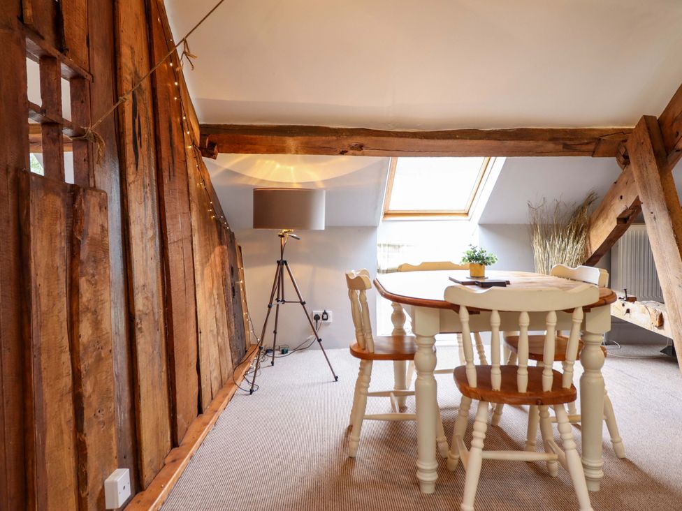 A dining room with a table and chairs at Millers Loft Llanrwst