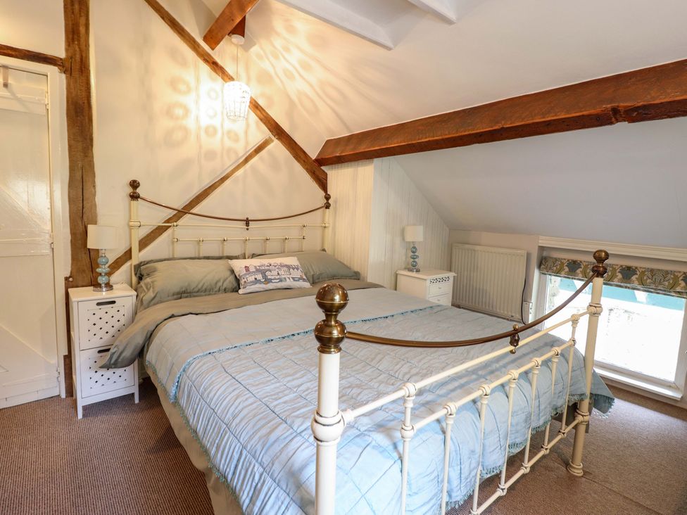A bedroom with a bed and nightstand at Millers Loft, Llanrwst