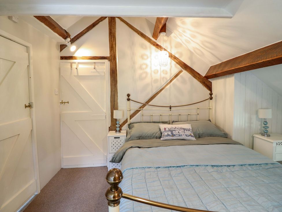 A bedroom with a bed and a wardrobe at Millers Loft in Llanrwst
