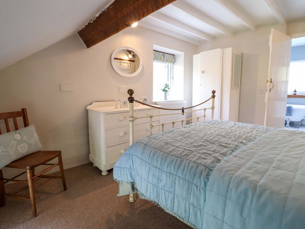 A bedroom with a bed and a dresser at Millers Loft in Llanrwst