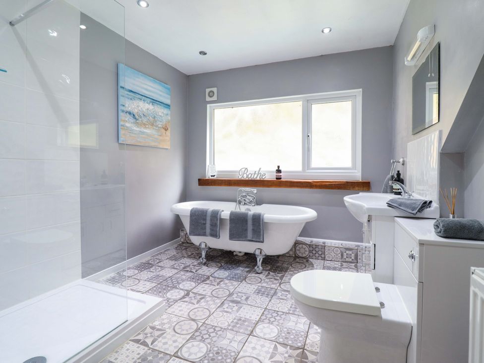 A bathroom with a bathtub and shower at Millers Loft in Llanrwst