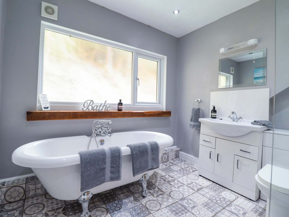 A bathroom with a bathtub and sink at Millers Loft in Llanrwst