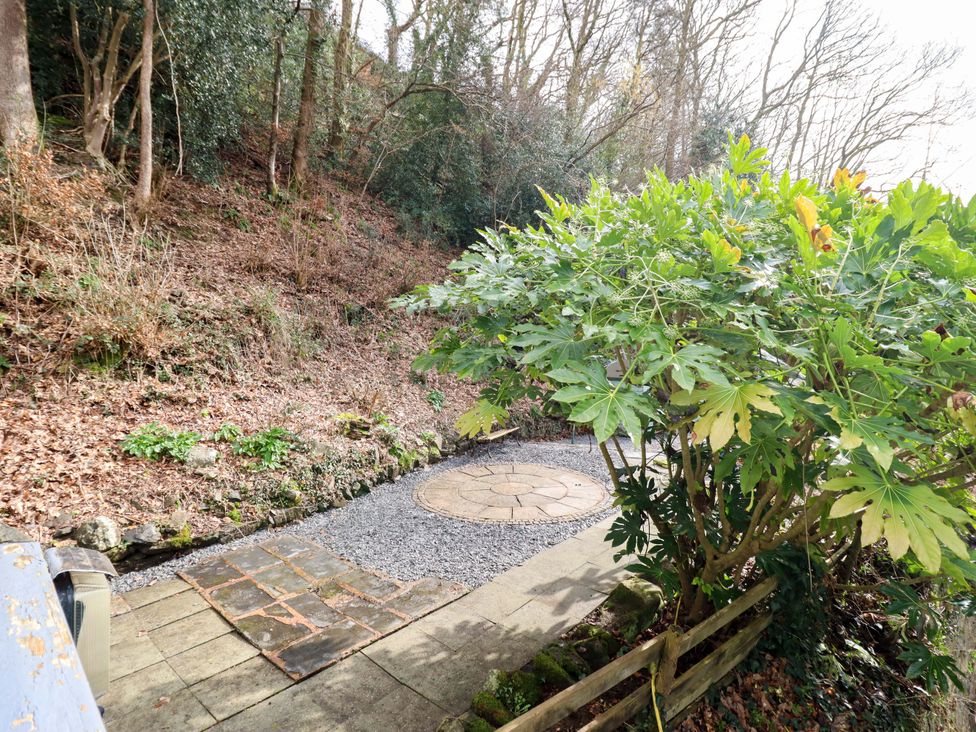 A garden with a gravel pathway and a circular stone feature at Millers Loft Llanrwst