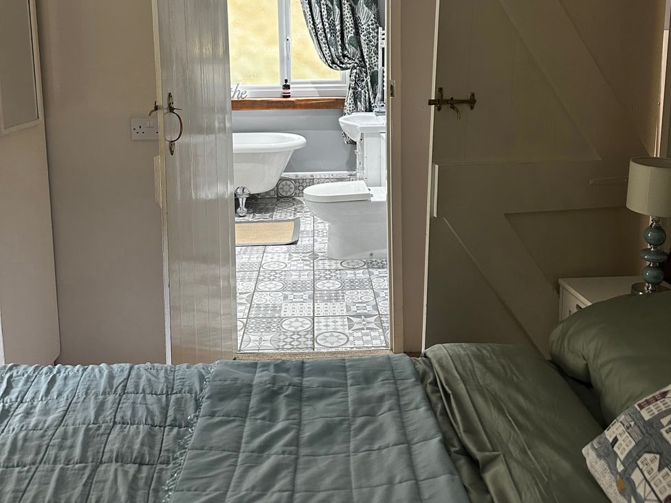 A bedroom with a view into the bathroom at Millers Loft in Maenan near Llanrwst