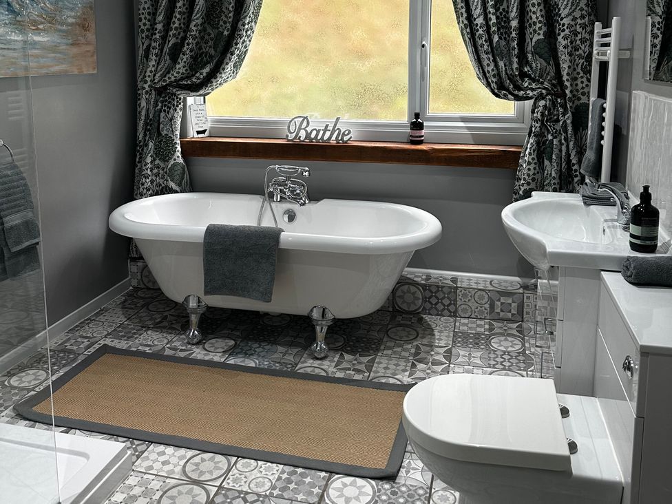 A bathroom with a bathtub, toilet, and sink at Millers Loft in Maenan near Llanrwst