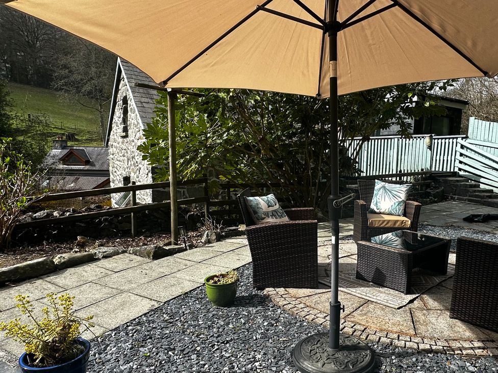An outdoor seating area with chairs and a table at Millers Loft in Maenan near Llanrwst