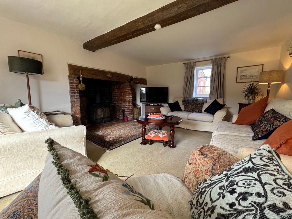 A living room with sofas and a television at Cutbush Farmhouse in Norwich