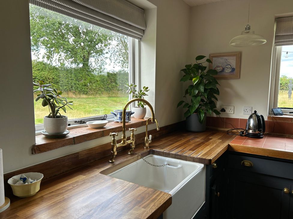 A kitchen with a sink and window at Cutbush Farmhouse in Norwich