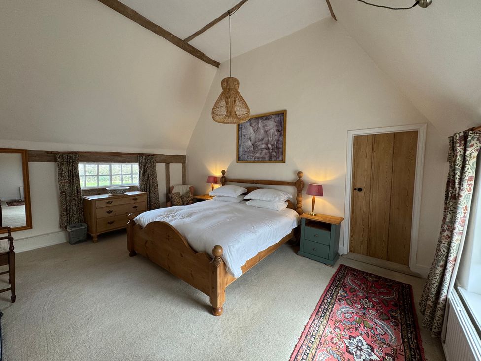 A bedroom with a bed and furniture at Cutbush Farmhouse in Norwich