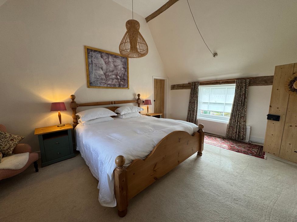 A bedroom with a bed and bedside tables at Cutbush Farmhouse in Norwich