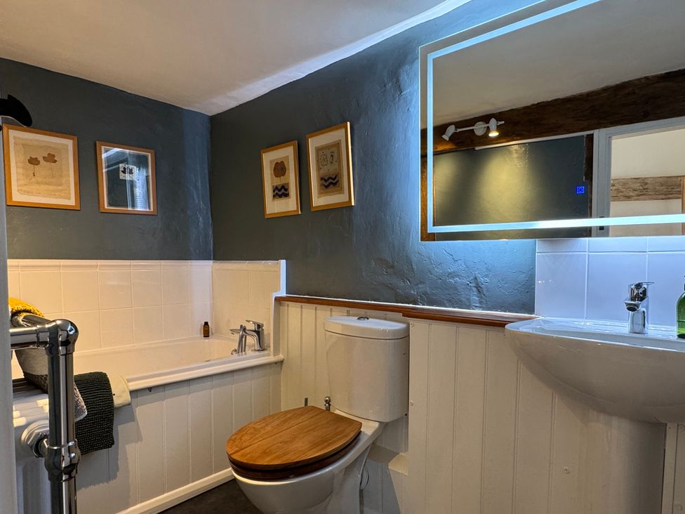 A bathroom featuring a bathtub, toilet, and sink at Cutbush Farmhouse in Norwich