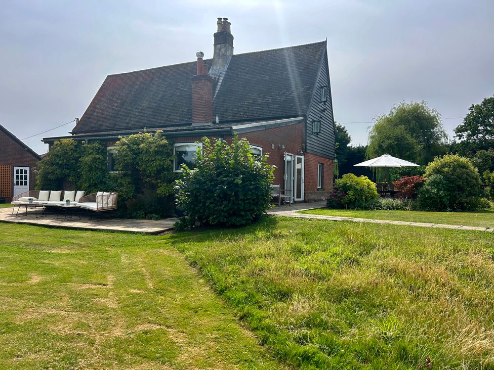 An outdoor area with a house and seating at Cutbush Farmhouse, Norwich