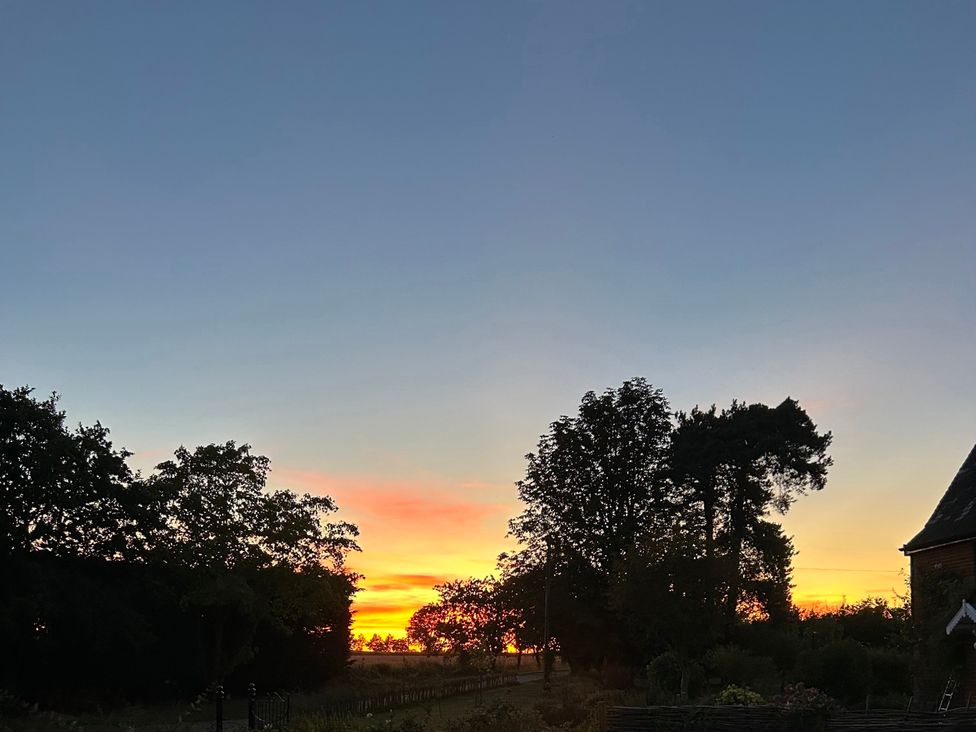 A sunset with trees in silhouette at Cutbush Farmhouse in Norwich