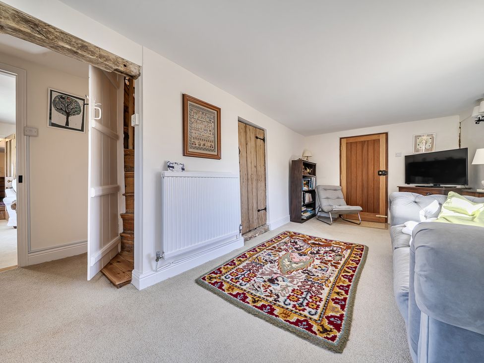 A living room with a rug and television at Cutbush Farmhouse in Hingham