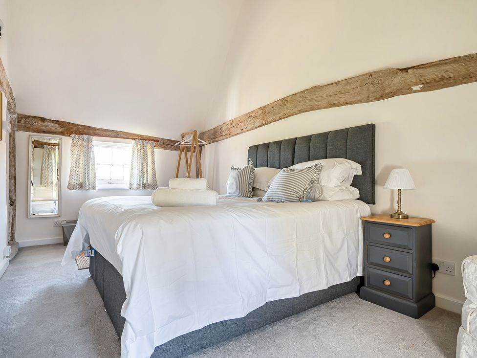 A bedroom with a gray bed and bedside table at Cutbush Farmhouse in Hingham