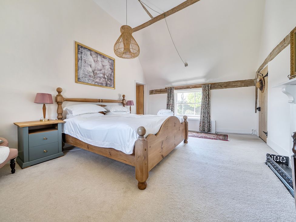 A bedroom with a large bed and nightstand at Cutbush Farmhouse in Hingham