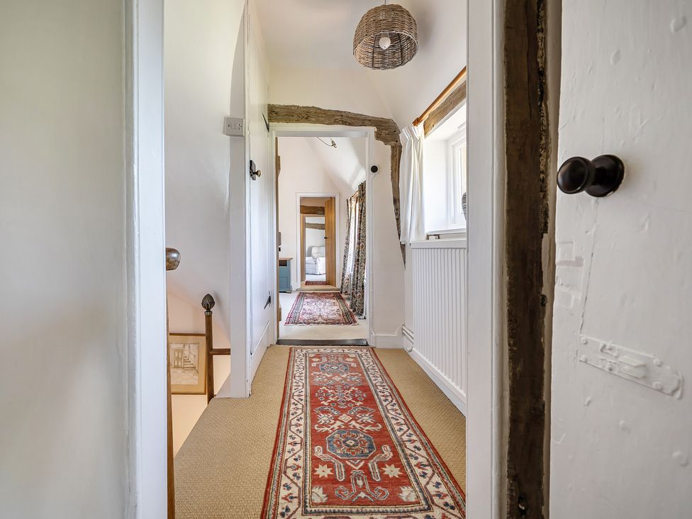 A hallway with carpet and lighting at Cutbush Farmhouse in Hingham