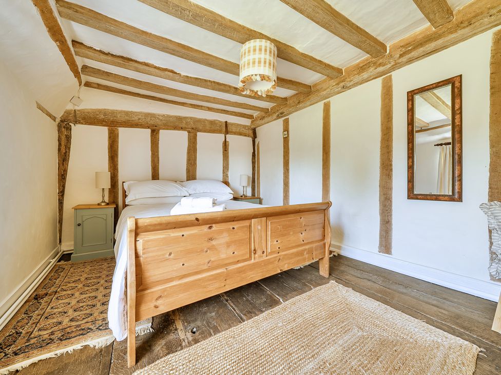 A bedroom with a bed and bedside table at Cutbush Farmhouse in Hingham