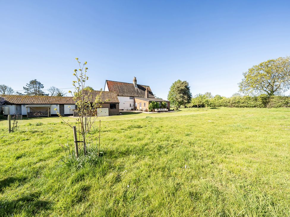 A house and field with trees at Cutbush Farmhouse in Hingham