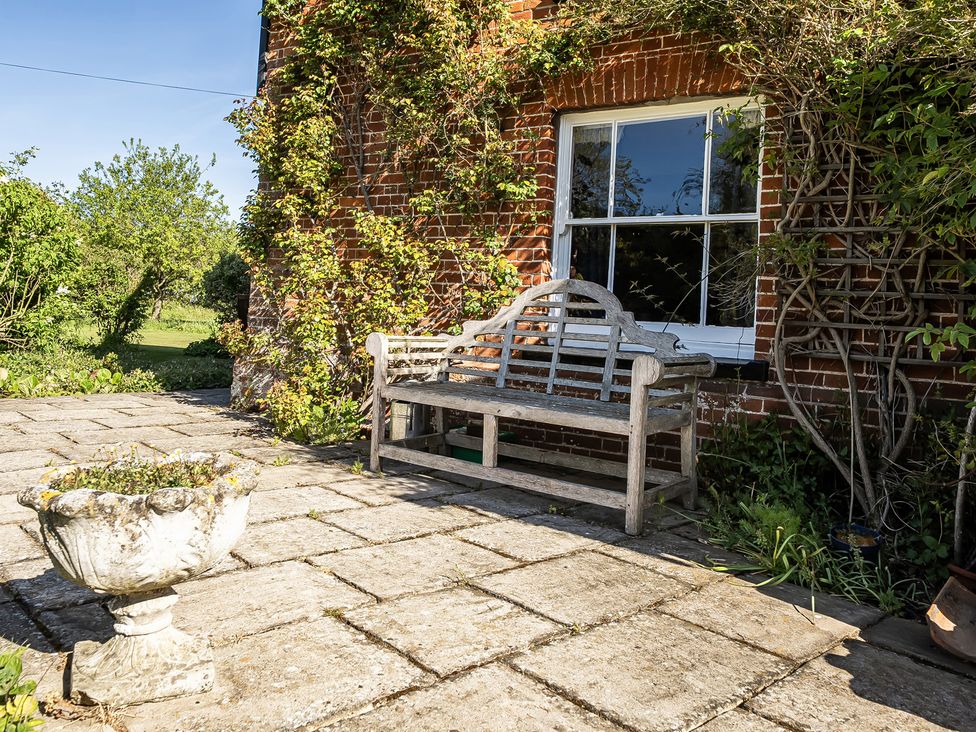 An outdoor area with a bench and flower pot at Cutbush Farmhouse Hingham