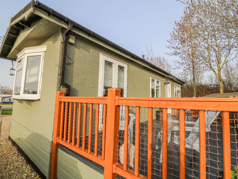 A house with a deck and fence at The Nest Lodge 55 Grantham