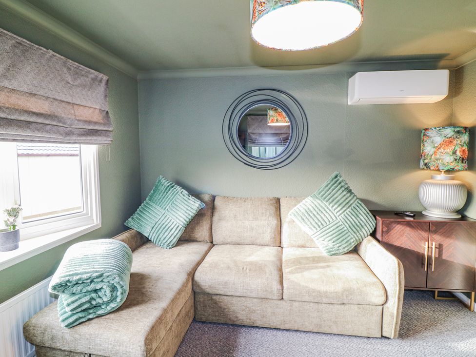 A snug with a sofa and plant at The Nest Lodge 55 Grantham