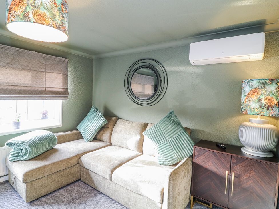 A living room with a sofa and lamp at The Nest Lodge 55 Grantham