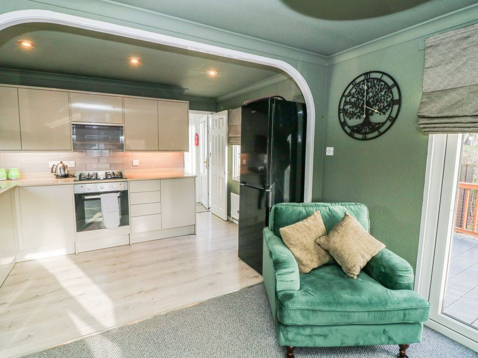 A kitchen with a stove and refrigerator at The Nest Lodge 55 in Grantham