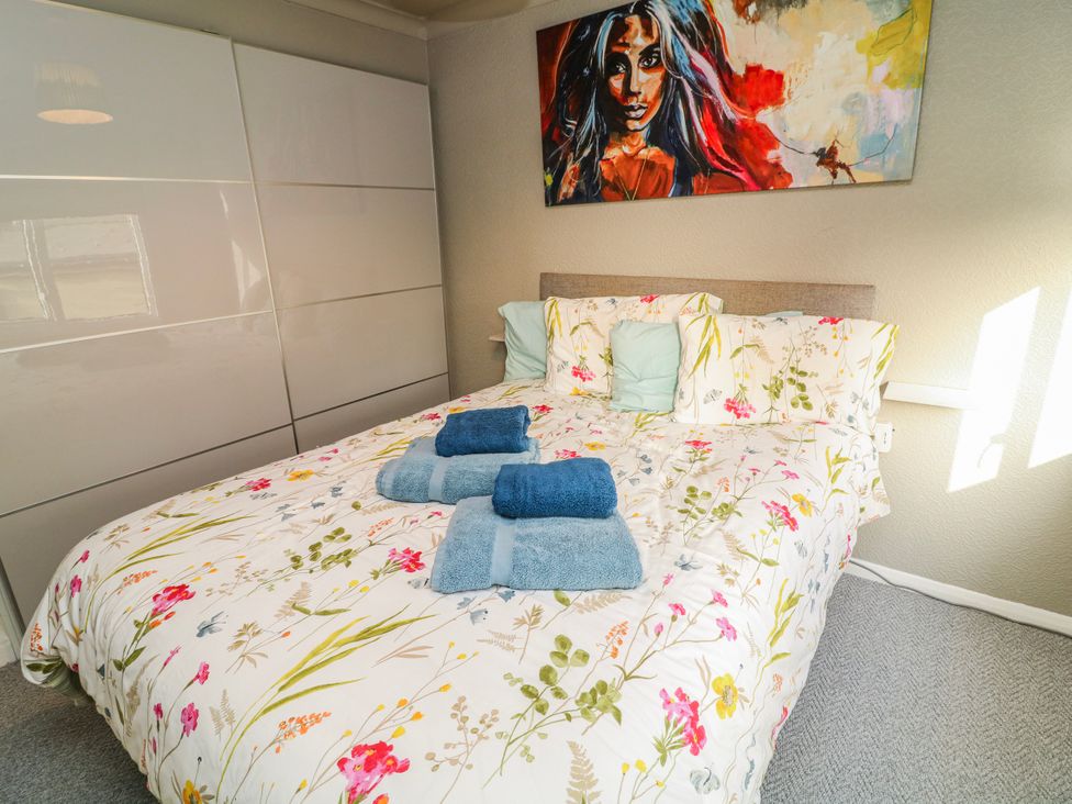 A bedroom with a bed and wardrobe at The Nest Lodge 55 in Grantham