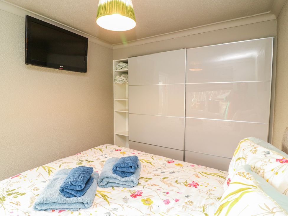 A bedroom with a bed and towels at The Nest Lodge 55 Grantham