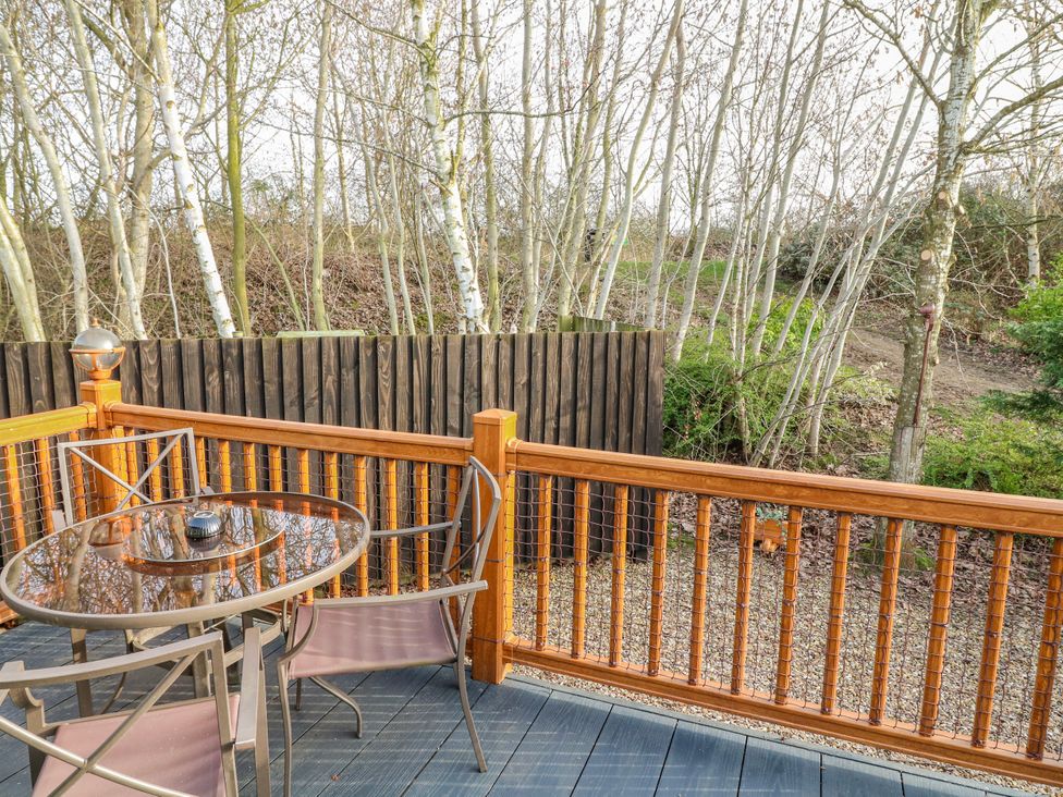 An outdoor patio with a table and chairs at The Nest Lodge 55 Grantham