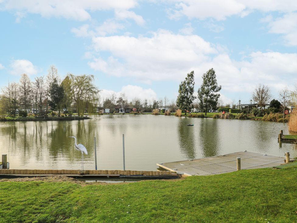 A view of a pond with trees and a dock at The Nest Lodge 55 Grantham