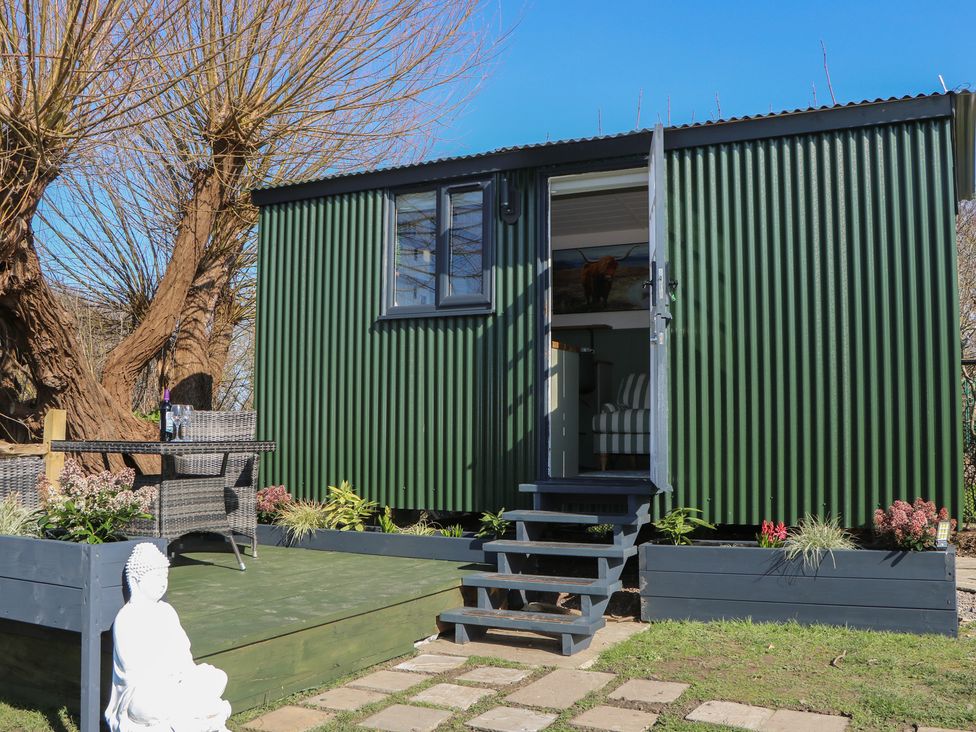 A hut with steps and seating area in the garden at Salt Haven Shepards Hut Pevensey