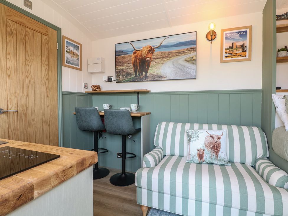 A snug room with a sofa and table in Salt Haven Shepards Hut Pevensey