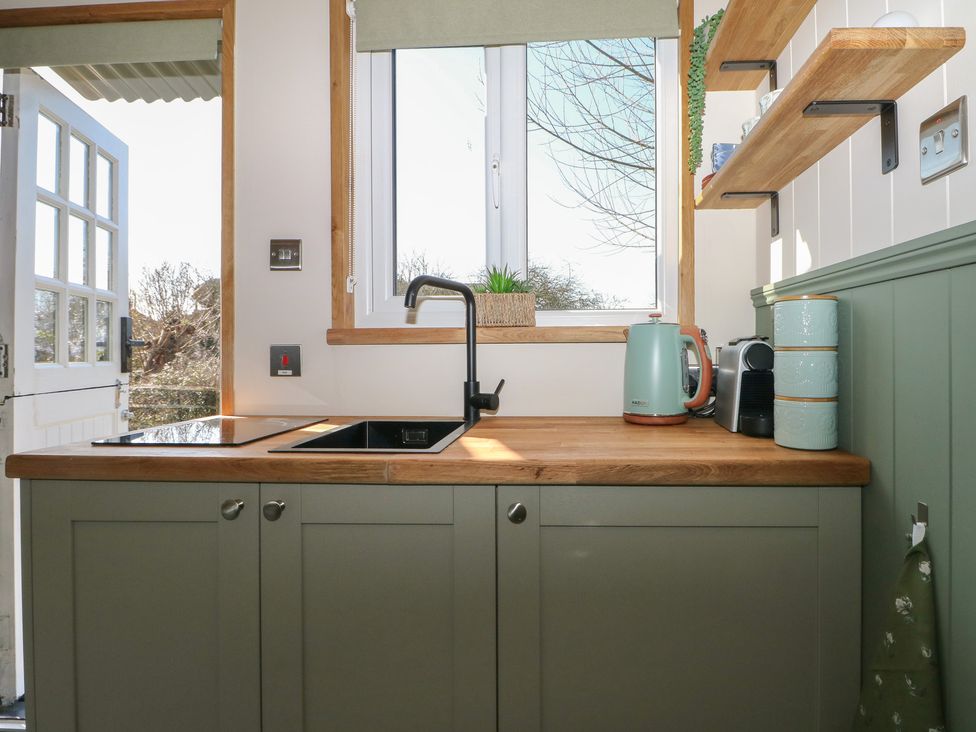 A kitchen with sink and stove at Salt Haven Shepards Hut Pevensey