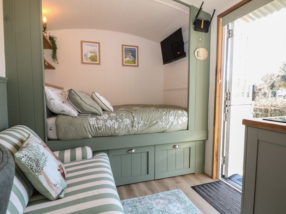 A snug with a bed and sofa at Salt Haven Shepards Hut Pevensey
