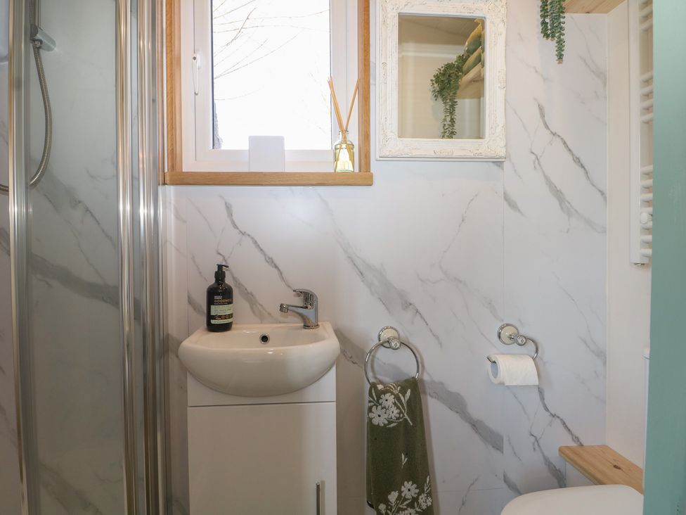 A bathroom with a sink and shower at Salt Haven Shepards Hut Pevensey