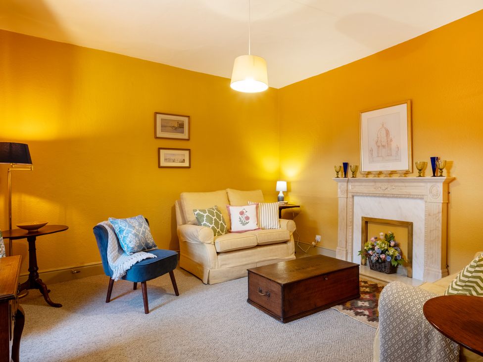A living room with a sofa and fireplace at Palace Garden Cottage in Bishop Auckland