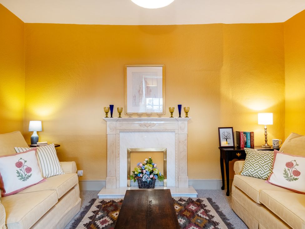 A living room with a fireplace and furniture at Palace Garden Cottage in Bishop Auckland