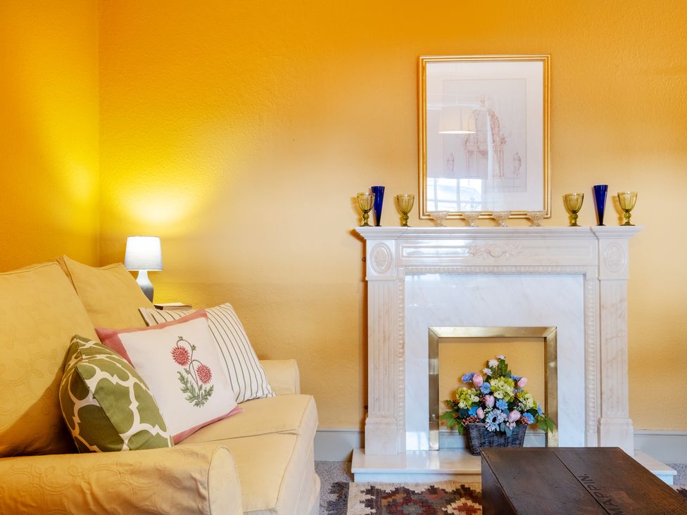 A living room with a sofa and fireplace at Palace Garden Cottage in Bishop Auckland