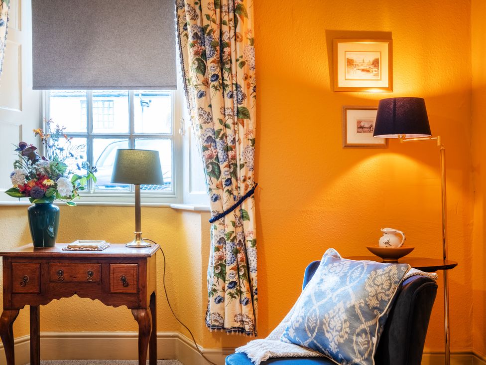 A living room with a window, table, and lamp at Palace Garden Cottage in Bishop Auckland
