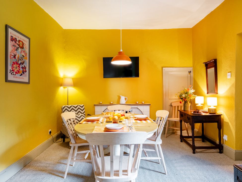 A dining room with a table and chairs at Palace Garden Cottage in Bishop Auckland