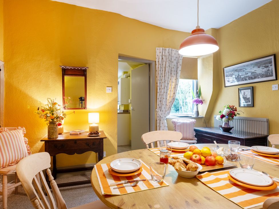 A dining room with a table set for meals at Palace Garden Cottage in Bishop Auckland