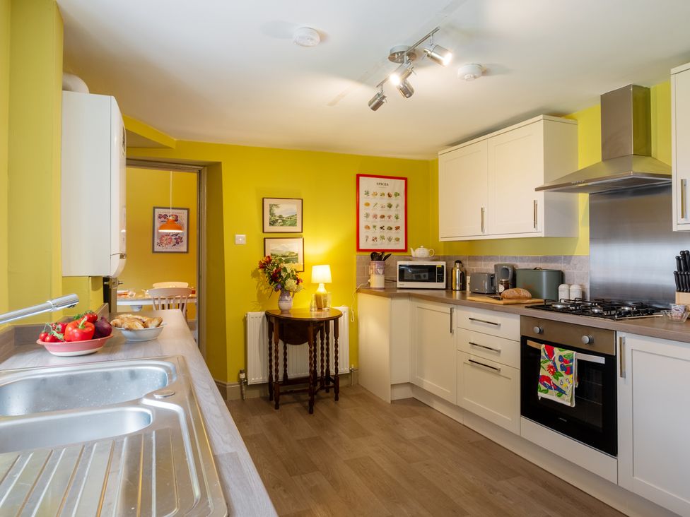 A kitchen with sink, cabinets, microwave and fruit bowl at Palace Garden Cottage in Bishop Auckland