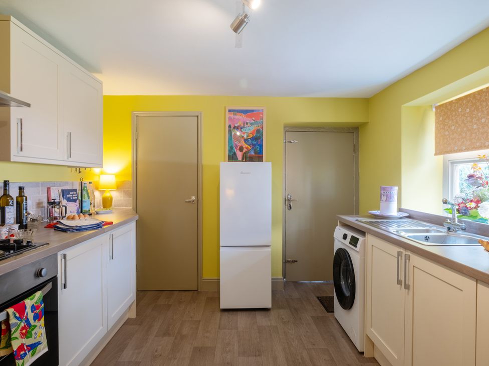 A kitchen with a refrigerator and washing machine at Palace Garden Cottage in Bishop Auckland