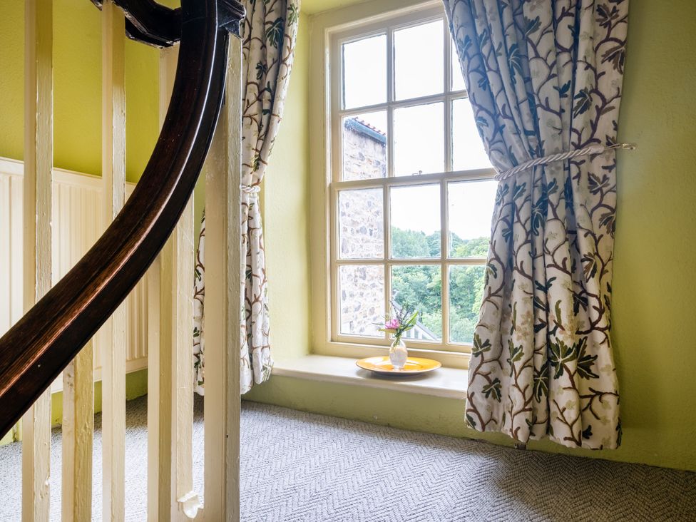 A staircase with curtains and a flower vase at Palace Garden Cottage Bishop Auckland