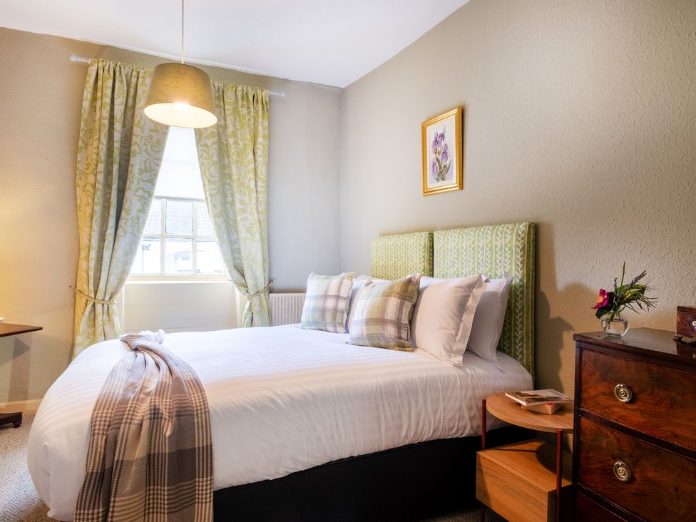 A bedroom with a bed and bedside table at Palace Garden Cottage in Bishop Auckland